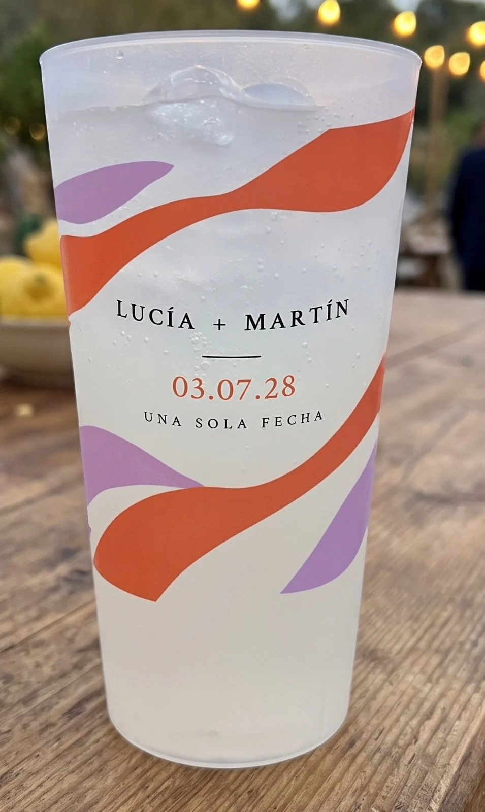 Detalle del vaso reutilizable de boda festival con los nombres y «Una sola fecha»
